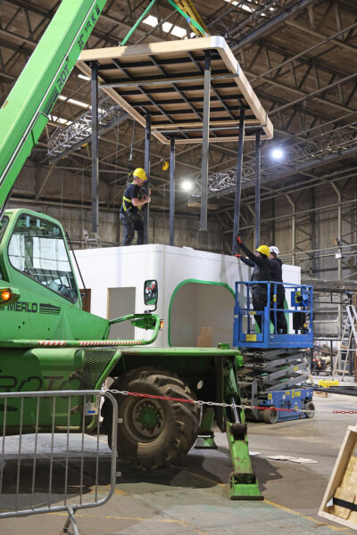 Crane lifting roof structure into place