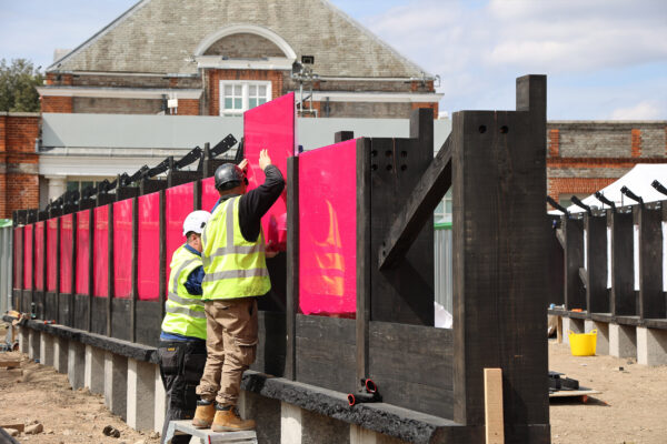 Fitting pink polycarbonate window panels at Serpentine Pavilion