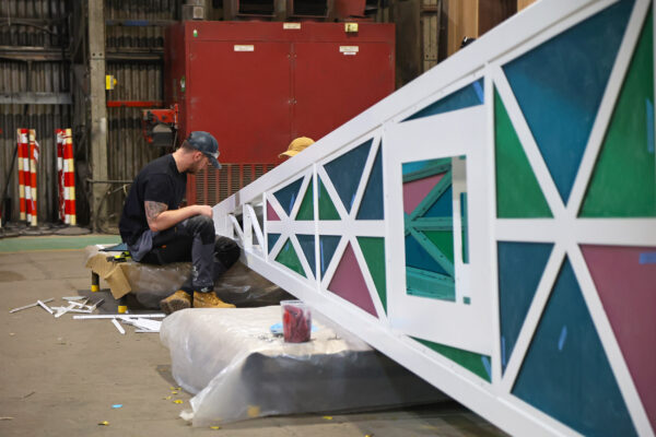 Stage One team installing colour perspex panels into a steel structure