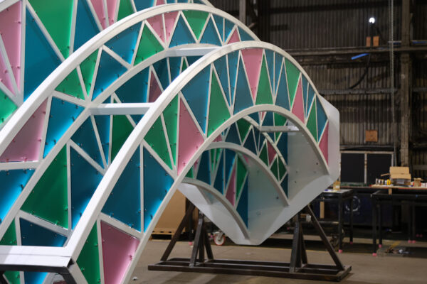 Framework of steel arch fitted with coloured perspex panels