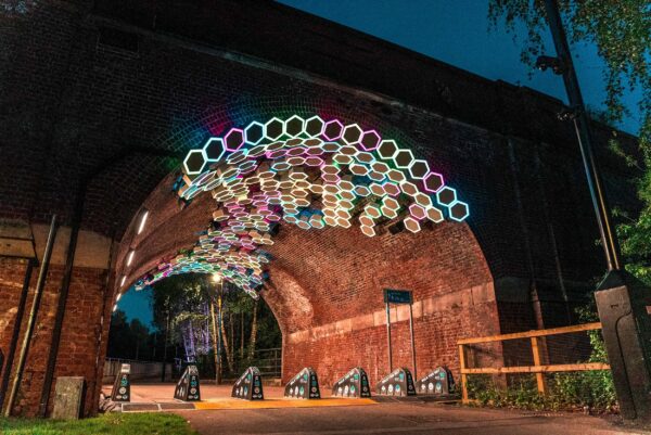 Image of viaduct with illuminated hexagonal lightboxes at night