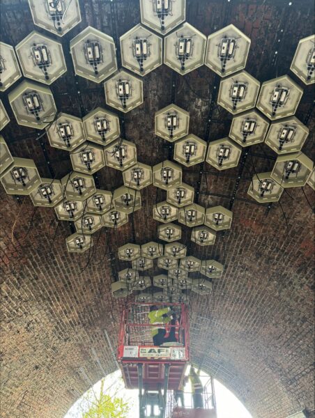 Hexagonal light boxes installed on brick ceiling of viaduct