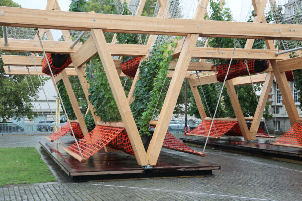 Timber v-shaped structure with net seating and climbing plants