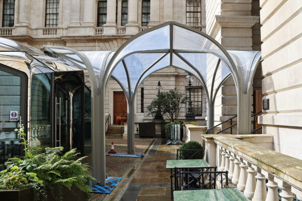 Steel canopy covering walkway between pavilion cafe and main building